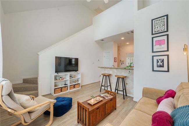 Living room featuring high vaulted ceiling, light wood finished floors, and stairs | Image 6