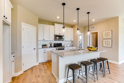 All of that beauty, yet still plenty of function! There's room to roam, a large walk-in pantry, awesome tiled-backsplash and vented micro-hood over the gas range! *Photo of previous model. Actual home may vary. | Image 1