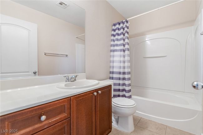 Full bathroom with vanity, tile patterned flooring, and shower / bath combo with shower curtain | Image 10