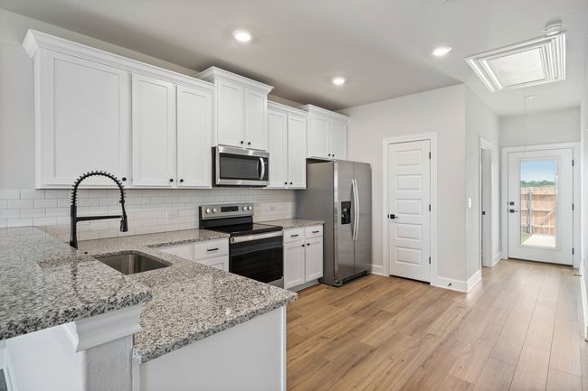 With its stainless steel appliances, granite countertops, and white cabinets, the kitchen is a stylish focal point that adds to the overall ambiance of the Arc. | Image 6