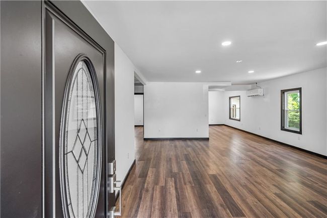 Foyer featuring a wall unit AC, wood finished floors, recessed lighting, and baseboards | Image 11