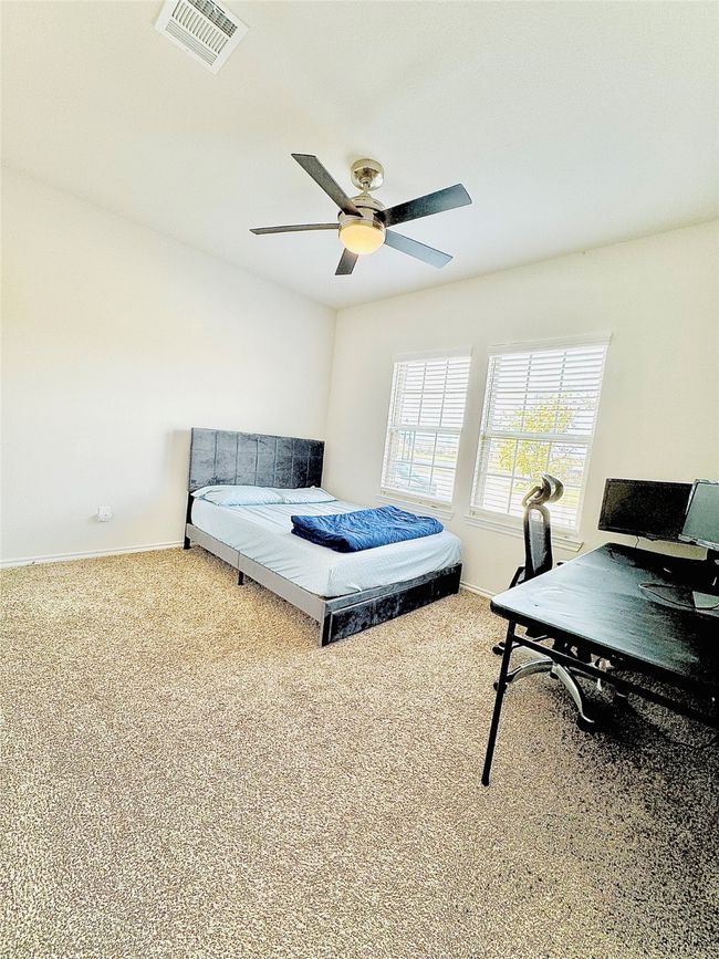 Carpeted bedroom with baseboards, a desk, and ceiling fan | Image 19