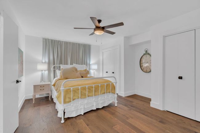 Bedroom featuring two closets, a ceiling fan, baseboards, and wood finished floors | Image 29
