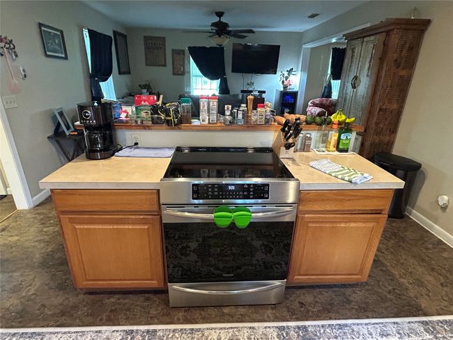 Kitchen featuring electric stove, light countertops, and ceiling fan | Image 16