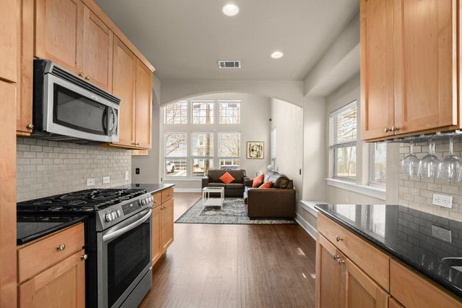 Kitchen featuring visible vents, open floor plan, dark wood finished floors, stainless steel appliances, and arched walkways | Image 13