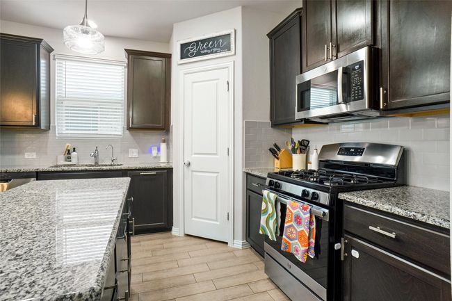 Kitchen with stainless steel appliances, a sink, and tasteful backsplash | Image 7