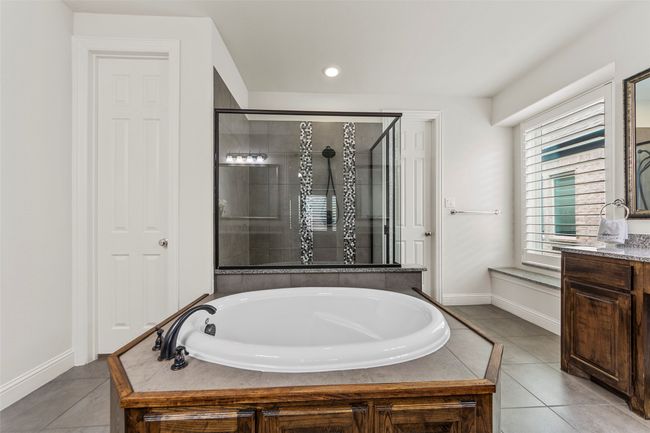 Full bathroom with a garden tub, a stall shower, baseboards, tile patterned floors, and vanity | Image 21