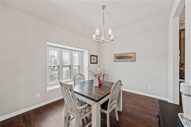 Dining room featuring dark wood-style floors, a chandelier, and baseboards | Image 4