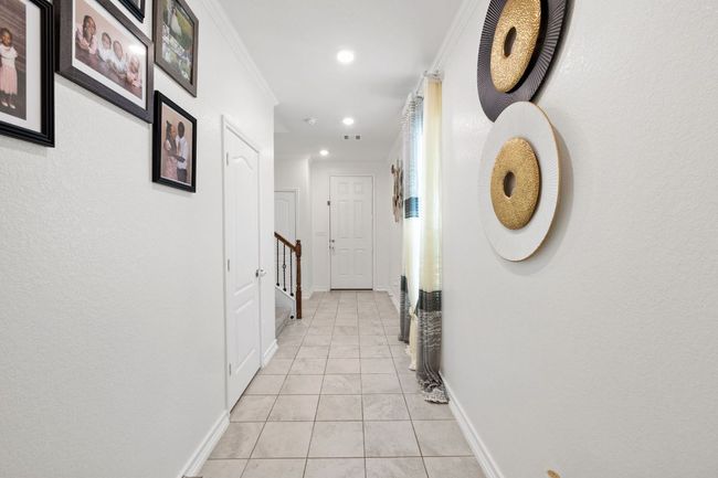 Hallway featuring recessed lighting, light tile patterned flooring, ornamental molding, and stairs | Image 5
