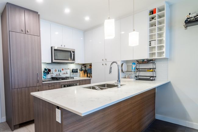 Kitchen with a peninsula, modern cabinets, and stainless steel microwave | Image 5