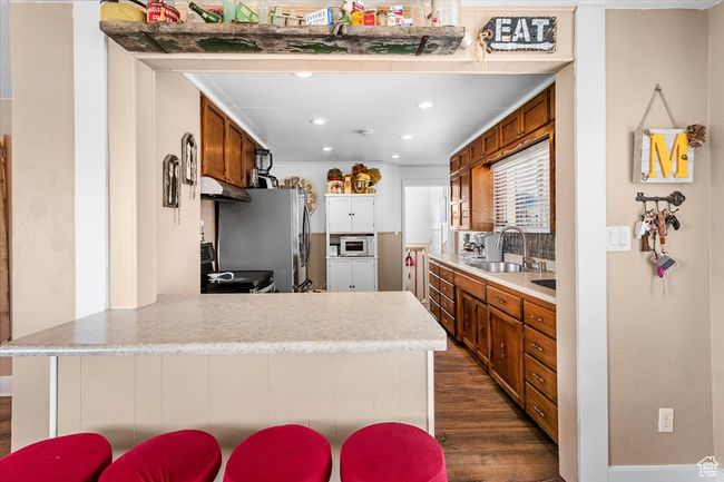 Kitchen featuring brown cabinets, a sink, and a peninsula | Image 24