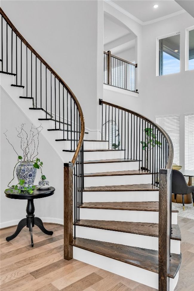 Stairs featuring a high ceiling, crown molding, and hardwood / wood-style floors | Image 12