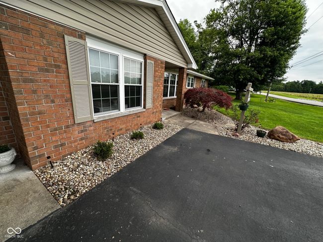 view of property exterior featuring a lawn and brick siding | Image 35