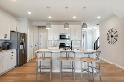 The Ashton's kitchen features a huge island surrounded by even more quartz counters. Durable and beautiful is a great combo! Photo of model home. | Image 3