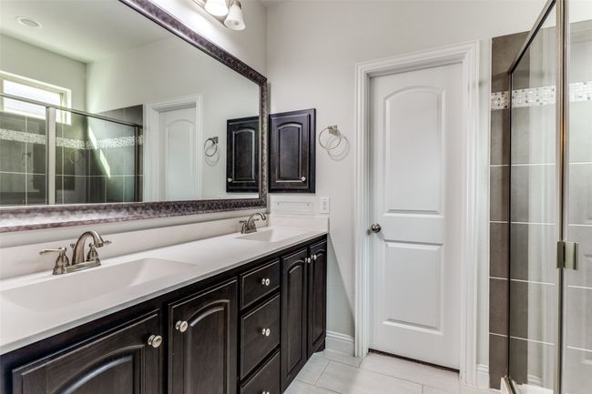 Bathroom featuring tile patterned floors, vanity, and a shower with shower door | Image 23