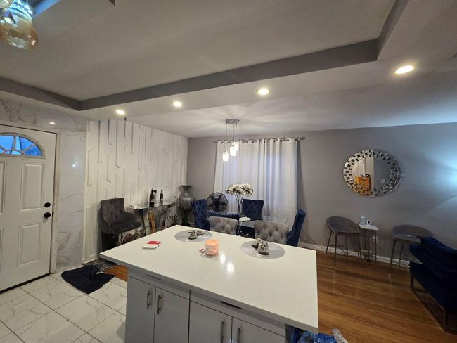 Kitchen featuring baseboards, recessed lighting, a center island, and light countertops | Image 4