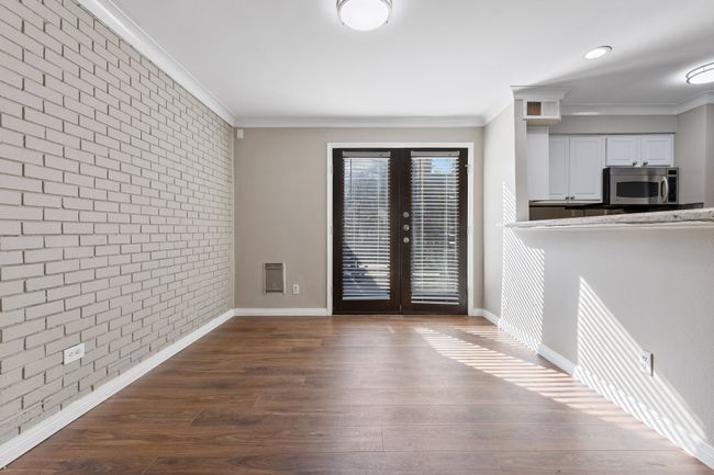 Unfurnished dining area featuring ornamental molding, french doors, and brick wall | Image 10