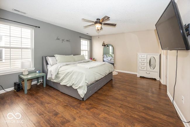 bedroom featuring wood finished floors, visible vents, a ceiling fan, and baseboards | Image 16