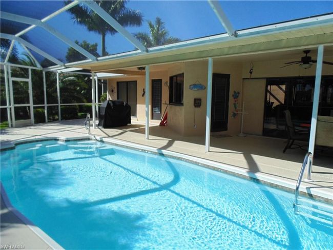Outdoor pool featuring a patio, glass enclosure, area for grilling, and a ceiling fan | Image 32