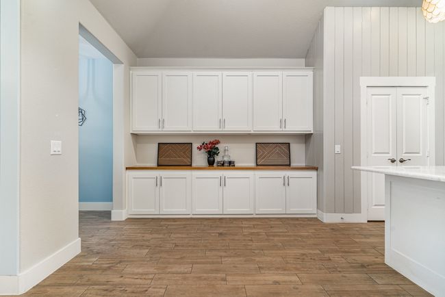 Kitchen with white cabinets, light wood-type flooring, light countertops, and baseboards | Image 14