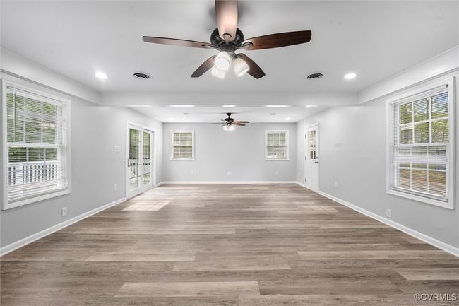 Unfurnished living room with visible vents, a ceiling fan, and light wood finished floors | Image 14