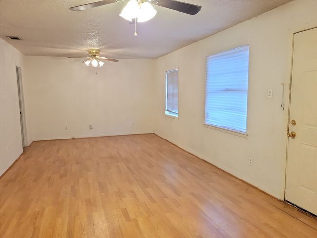 Unfurnished room with a ceiling fan, light wood-type flooring, and a textured ceiling | Image 6