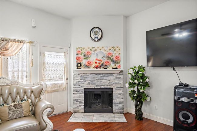 The living room’s focal point is the custom stone fireplace surround, which adds texture, depth, and a modern touch to the space—both a functional and aesthetic upgrade that enhances the room’s character. | Image 5