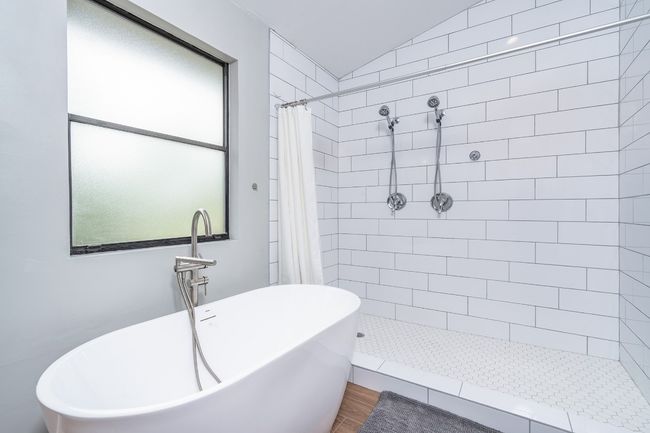 Full bathroom with vaulted ceiling, wood finished floors, a soaking tub, and tiled shower | Image 20