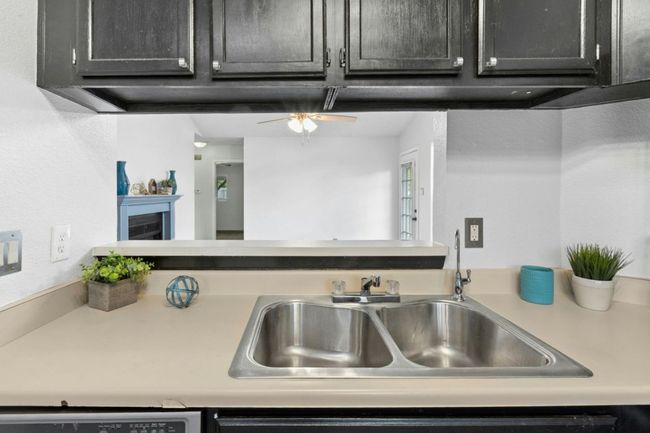 Kitchen with light countertops, a ceiling fan, and a fireplace | Image 15