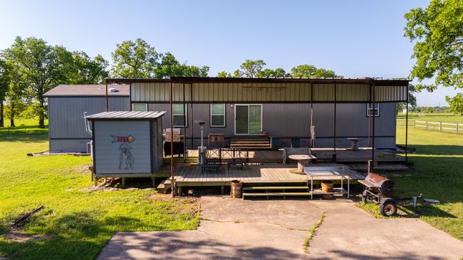 Back of property with a yard, a wooden deck, and an outbuilding | Image 23