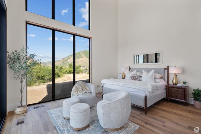 Bedroom featuring a high ceiling, a mountain view, access to outside, and wood finished floors | Image 39