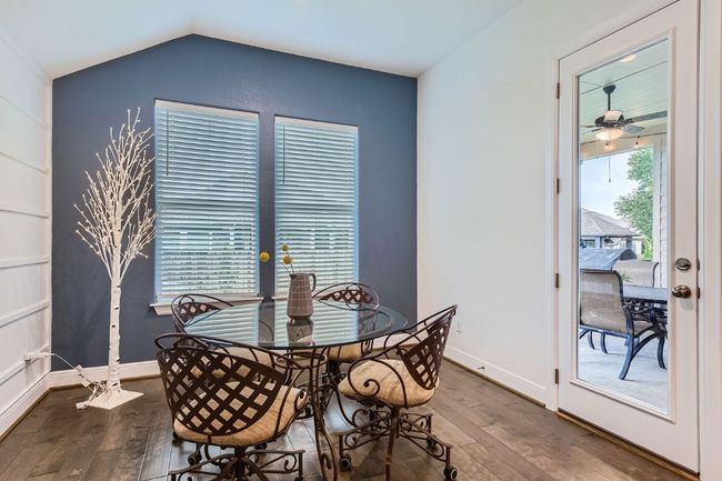 Dining space with dark wood finished floors, a ceiling fan, and vaulted ceiling | Image 13