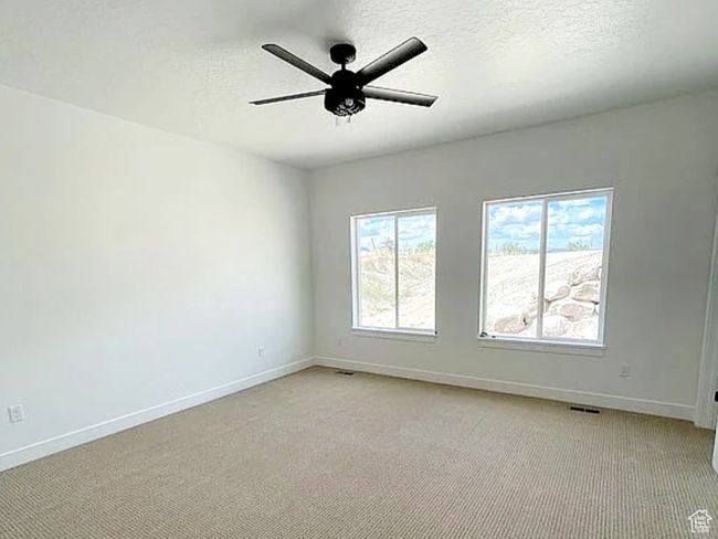 Unfurnished room with light carpet, a textured ceiling, a ceiling fan, and baseboards | Image 19