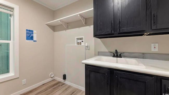 Laundry area with cabinet space, washer hookup, light wood finished floors, and baseboards | Image 34