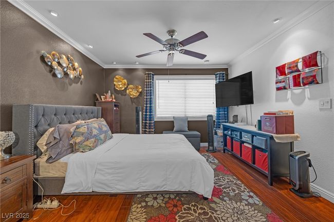 Bedroom with baseboards, ornamental molding, wood finished floors, and ceiling fan | Image 5