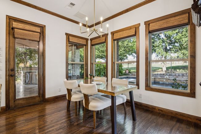 Dining area featuring crown molding, plenty of natural light, dark wood-type flooring, and a chandelier | Image 10