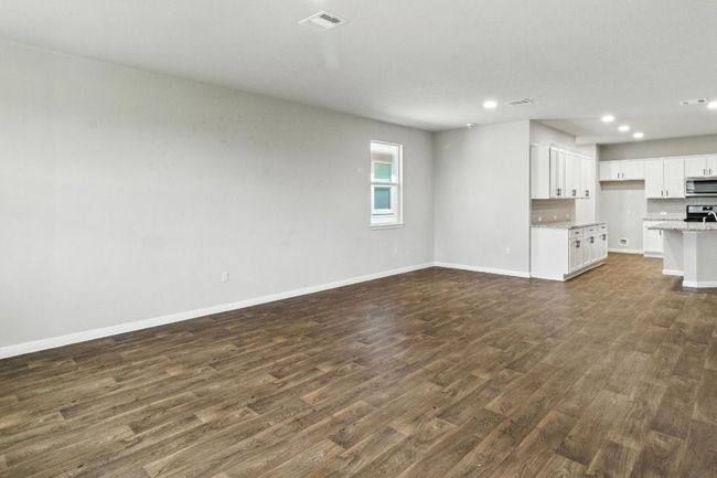 Unfurnished living room with dark wood finished floors and recessed lighting | Image 6