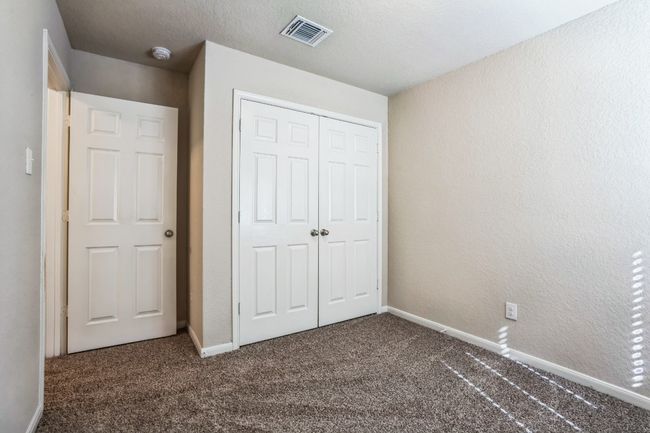 Unfurnished bedroom with a closet and dark colored carpet | Image 18