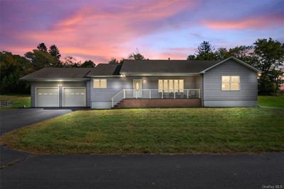 Single story home with a garage, a lawn, and covered porch | Image 1