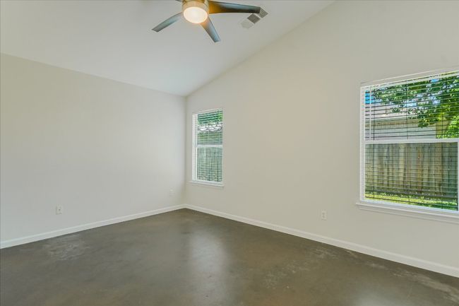 Stunning ceilings and huge Primary bedroom-large enough for a California King bed along w/ other furniture. Vaulted ceiling, modern ceiling fan, stained concrete fresh paint | Image 9
