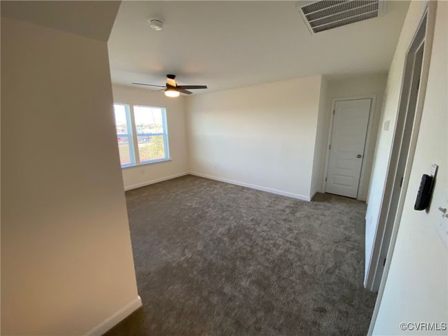 Spare room with dark colored carpet, ceiling fan, baseboards, and a smoke detector | Image 26