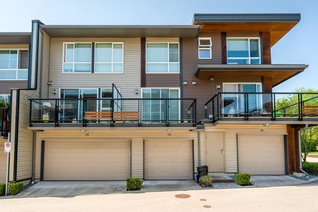 Rear view of property with concrete driveway, an attached garage, and a balcony | Image 21