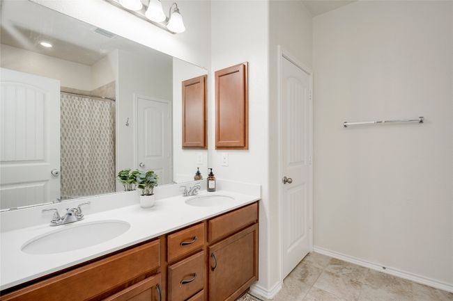 Bathroom featuring double vanity and curtained shower | Image 14