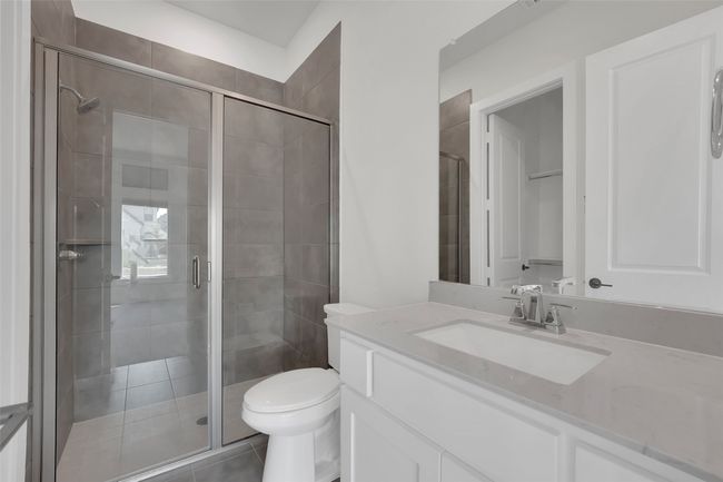 Bathroom featuring vanity, tile patterned flooring, a shower stall, and toilet | Image 18
