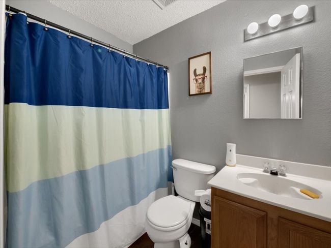 Bathroom with toilet, vanity, and a textured ceiling | Image 21
