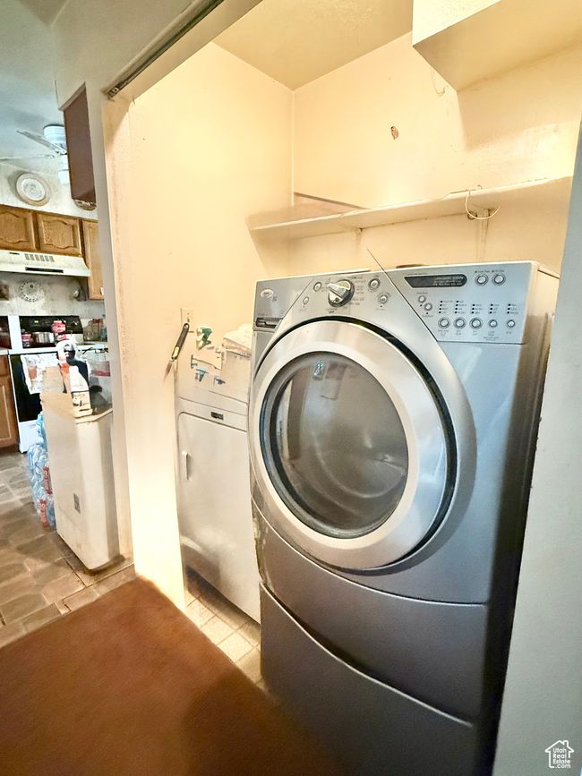 Laundry room featuring light tile patterned floors and washer and clothes dryer | Image 9