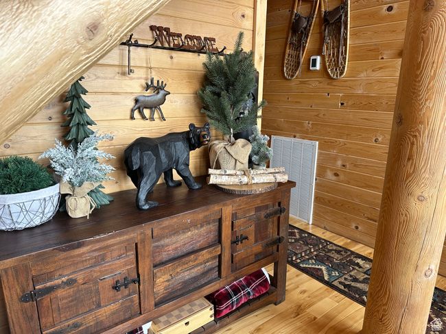 Mudroom with wood finished floors, wood walls, and visible vents | Image 11