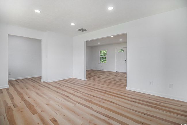 Living room featuring new luxury vinyl plank flooring, recessed LED lighting, and all new paint. | Image 15