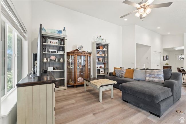 Living area featuring light wood-style floors, a ceiling fan, and recessed lighting | Image 4
