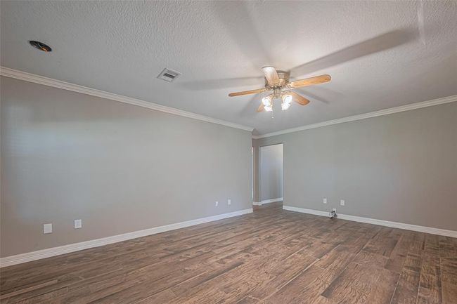 Open concept main living area offers tile flooring, crown molding, and loads of natural lighting from a large picture window overlooking the sun room and lush backyard | Image 8